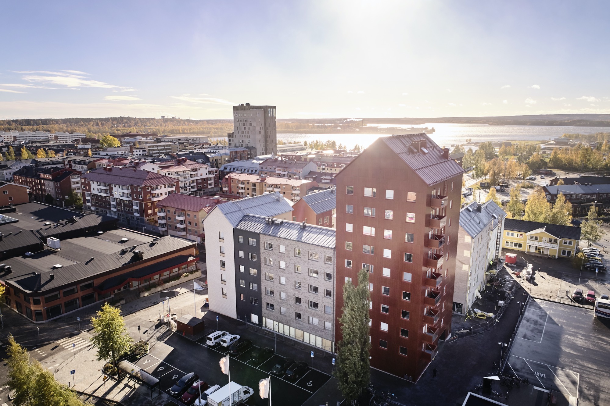 Korkea puurunkoinen asuinkerrostalo kaupungin keskustassa